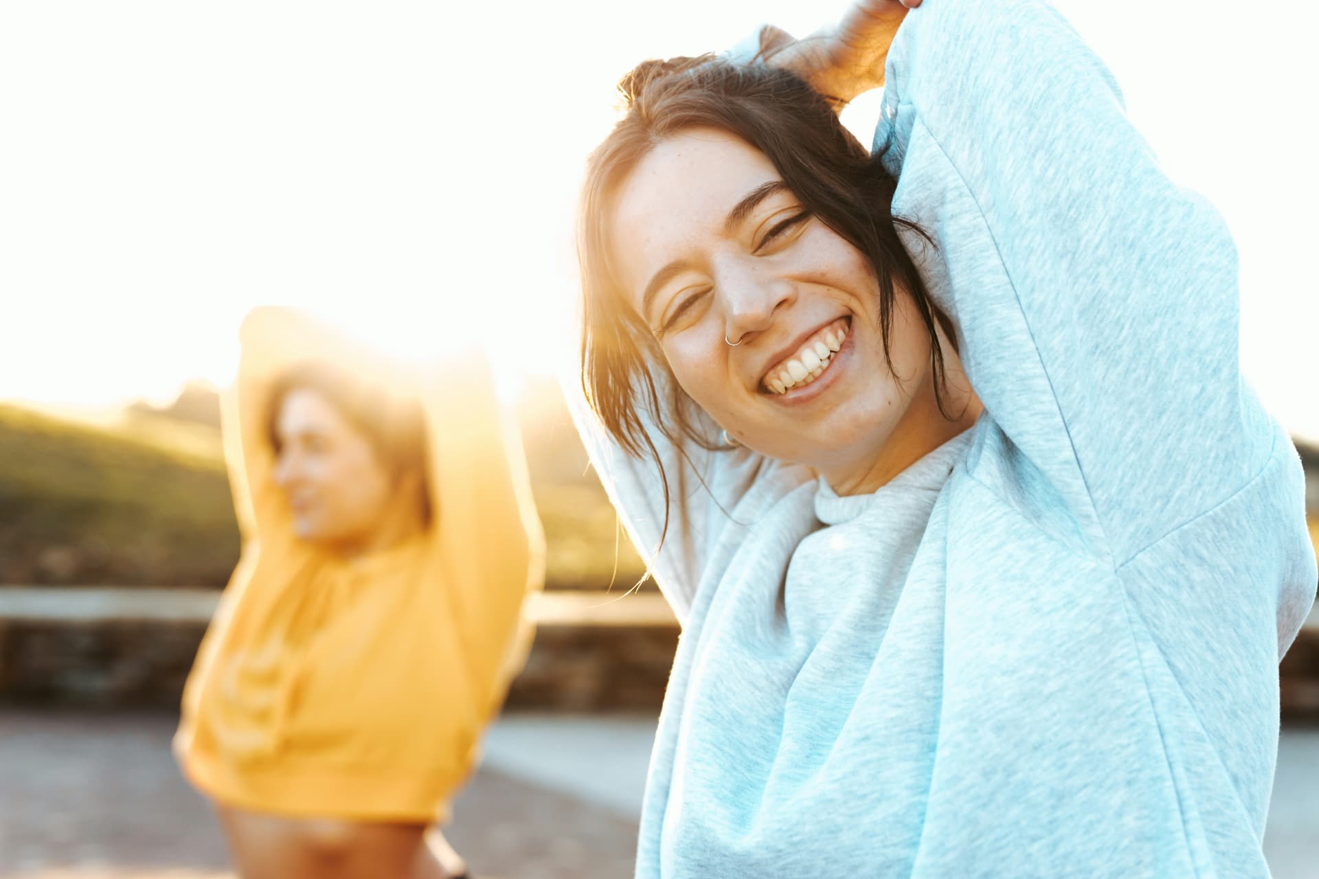 Two people stretching outdoors at sunrise